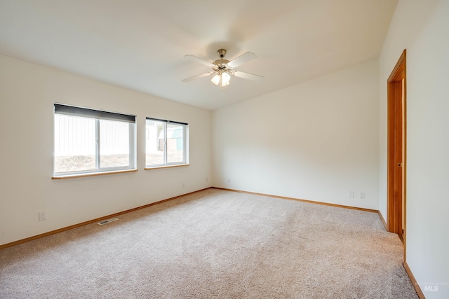 spare room featuring visible vents, carpet floors, baseboards, and a ceiling fan