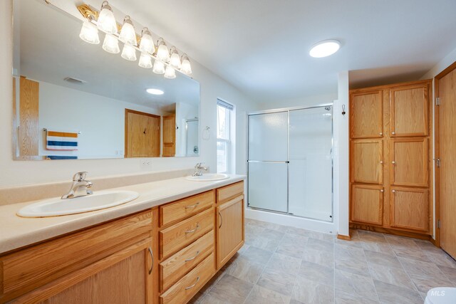 bathroom with a sink, visible vents, a stall shower, and double vanity