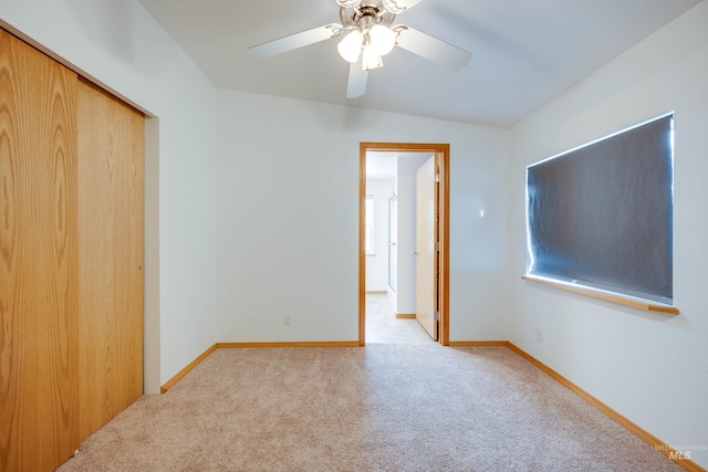 unfurnished bedroom featuring carpet flooring, baseboards, a closet, and ceiling fan