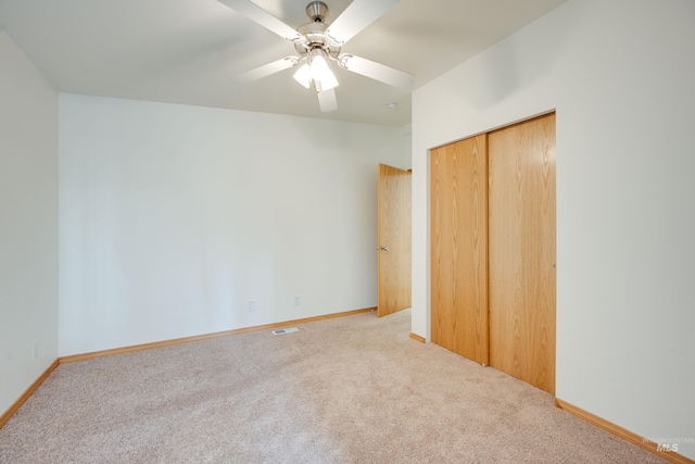 unfurnished bedroom featuring a closet, baseboards, carpet, and a ceiling fan