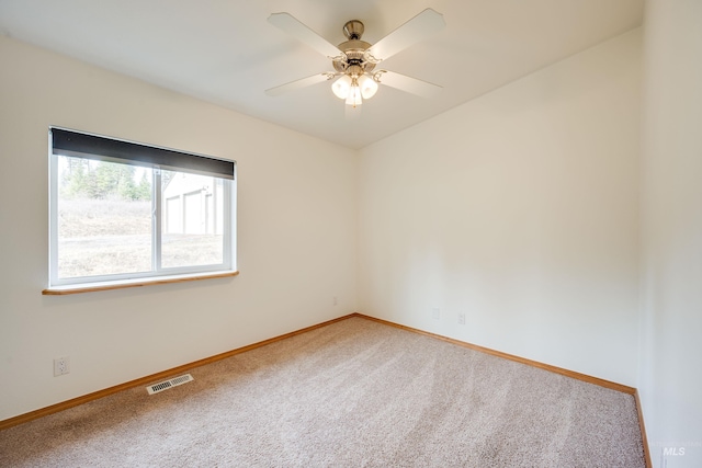 unfurnished room with visible vents, baseboards, light colored carpet, and ceiling fan