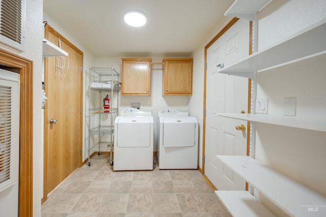 washroom with separate washer and dryer and cabinet space