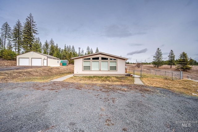 view of front of home with an outbuilding, a garage, and fence