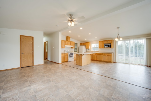 kitchen with lofted ceiling, a kitchen island, white appliances, light countertops, and baseboards