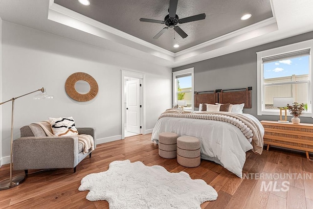 2251 N Garnet Creek Ave, Star, ID 83669 - bedroom featuring a tray ceiling, ornamental molding, hardwood / wood-style floors, baseboards, and a ceiling fan