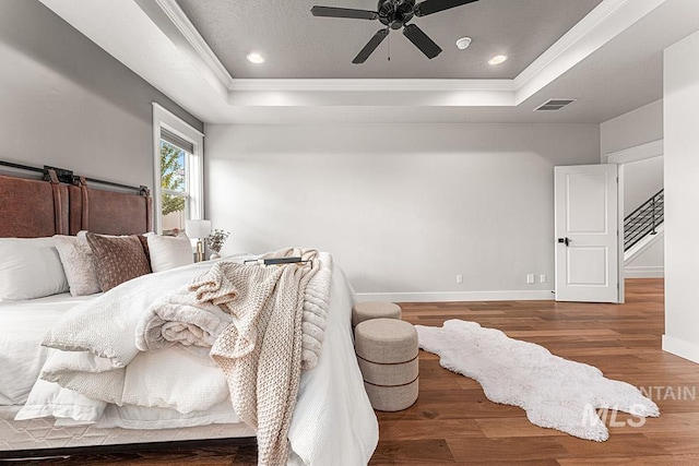 2251 N Garnet Creek Ave, Star, ID 83669 - bedroom featuring a tray ceiling, ornamental molding, baseboards, wood finished floors, and a ceiling fan