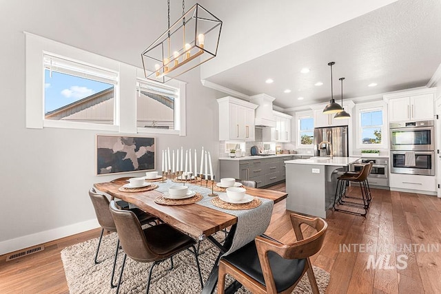 2251 N Garnet Creek Ave, Star, ID 83669 - dining area with recessed lighting, wood finished floors, baseboards, ornamental molding, and a chandelier