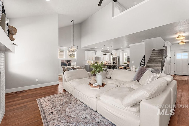 2251 N Garnet Creek Ave, Star, ID 83669 - living room with stairway, baseboards, wood finished floors, a chandelier, and high vaulted ceiling