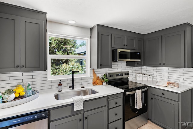 905 E 2nd St, Emmett, ID 83617 - kitchen featuring appliances with stainless steel finishes, gray cabinetry, decorative backsplash, and light countertops