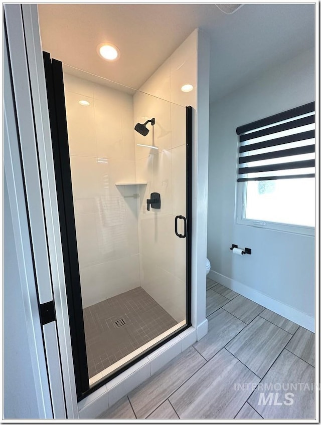 1514 W River St Unit 207, Boise, ID 83702 - bathroom with a stall shower, toilet, baseboards, recessed lighting, and wood tiled floors