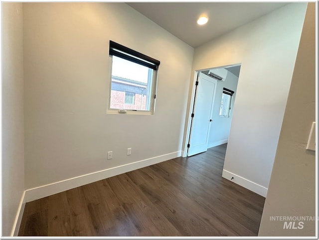 1514 W River St Unit 207, Boise, ID 83702 - spare room featuring dark wood-style flooring, baseboards, and an AC wall unit