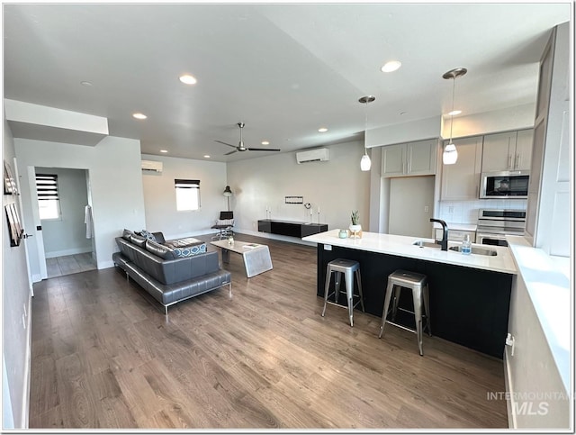 1514 W River St Unit 207, Boise, ID 83702 - living area with an AC wall unit, a ceiling fan, wood finished floors, recessed lighting, and baseboards
