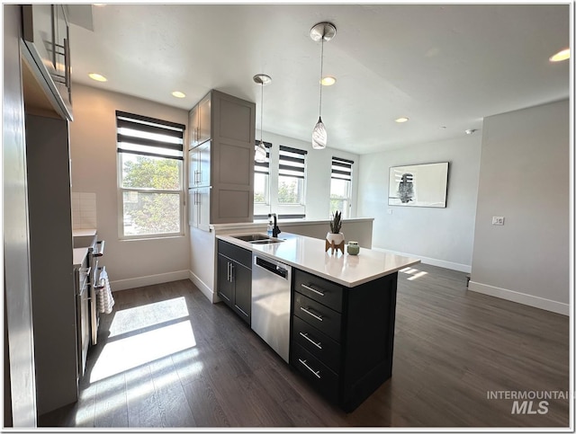 1514 W River St Unit 207, Boise, ID 83702 - kitchen with stainless steel dishwasher, a peninsula, baseboards, light countertops, and dark wood-style flooring