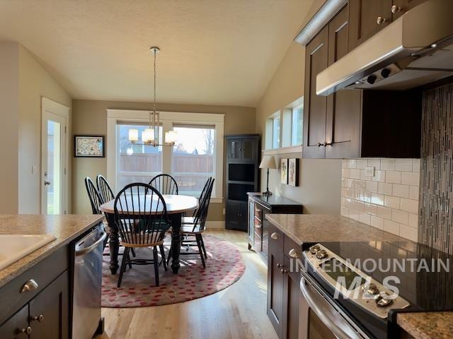 kitchen with appliances with stainless steel finishes, light wood-type flooring, lofted ceiling, and dark brown cabinetry