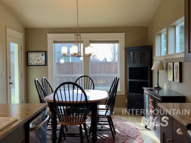 dining area featuring a notable chandelier and vaulted ceiling