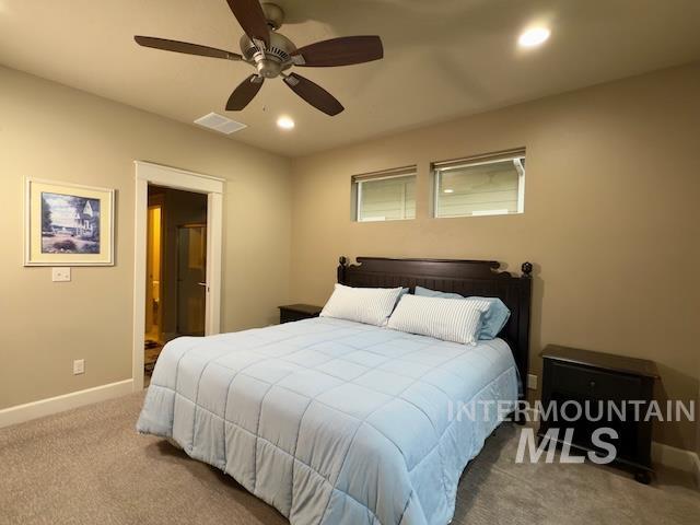 carpeted bedroom featuring ceiling fan and ensuite bathroom