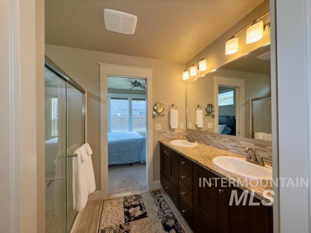 bathroom with vanity, tasteful backsplash, a shower with shower door, and ceiling fan