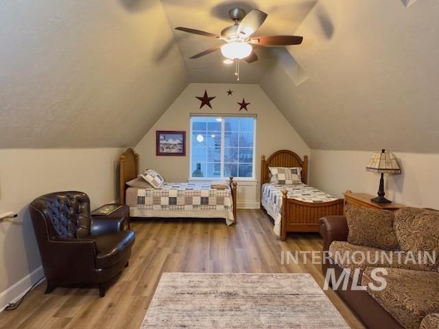 bedroom with vaulted ceiling, ceiling fan, and hardwood / wood-style floors