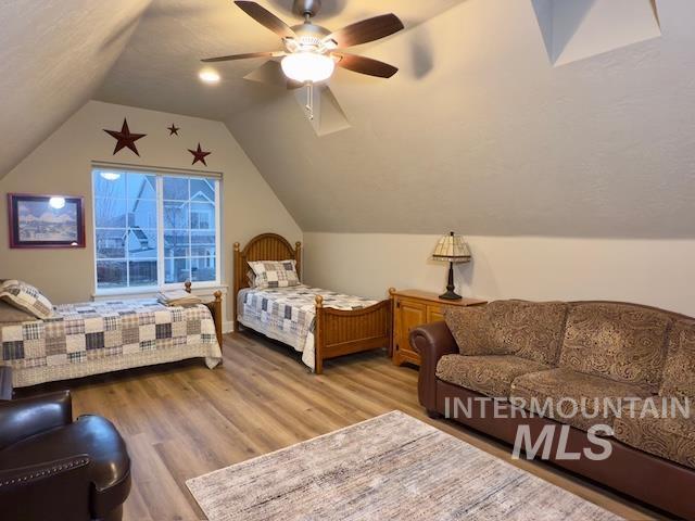 bedroom with lofted ceiling, ceiling fan, and light wood-type flooring