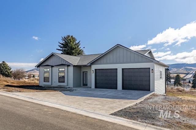 view of front facade featuring board and batten siding, driveway, a shingled roof, and an attached garage