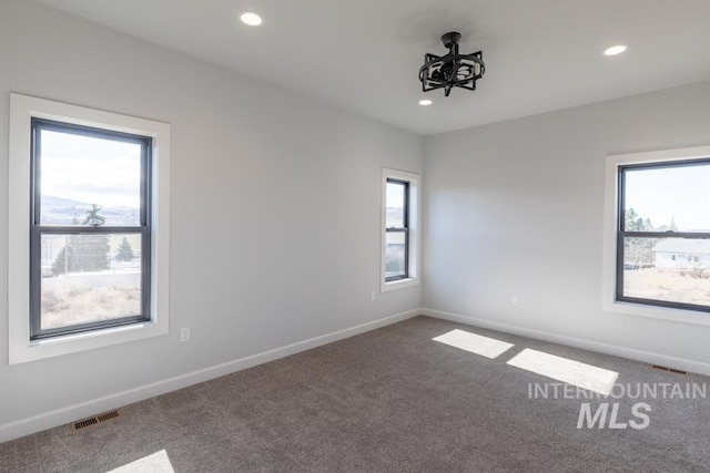 spare room featuring carpet floors, recessed lighting, visible vents, and baseboards