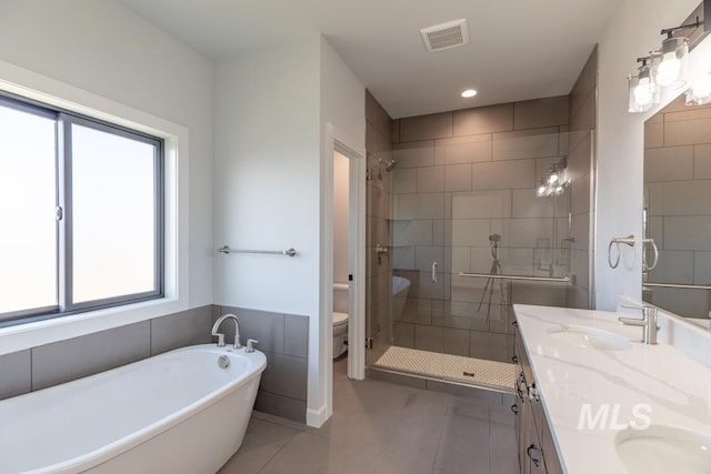 full bath with double vanity, visible vents, toilet, a shower stall, and a sink