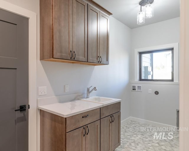 clothes washing area featuring washer hookup, a sink, cabinet space, and baseboards