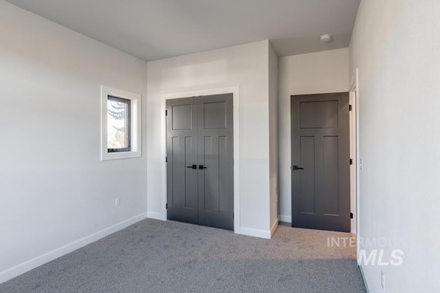 unfurnished bedroom with carpet floors, baseboards, and a closet