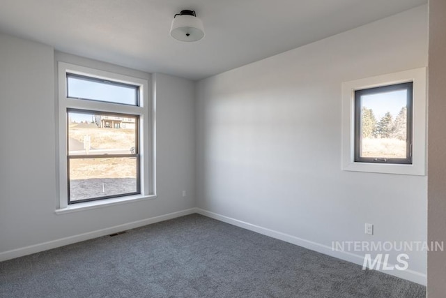 carpeted empty room featuring baseboards