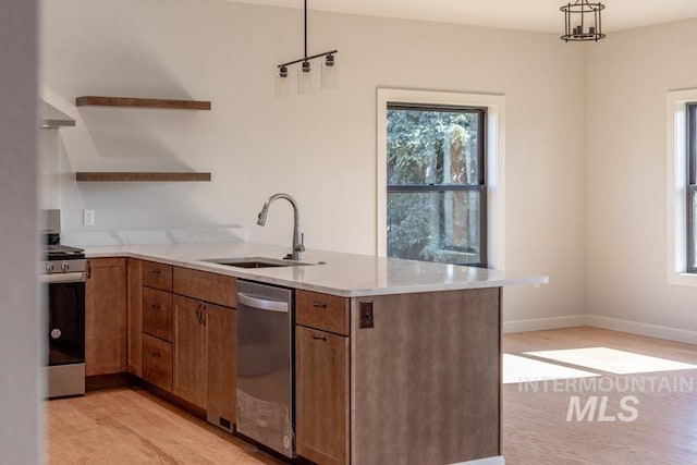 kitchen featuring appliances with stainless steel finishes, brown cabinets, a peninsula, open shelves, and a sink