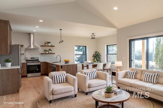 living room with lofted ceiling, light wood-style flooring, and recessed lighting