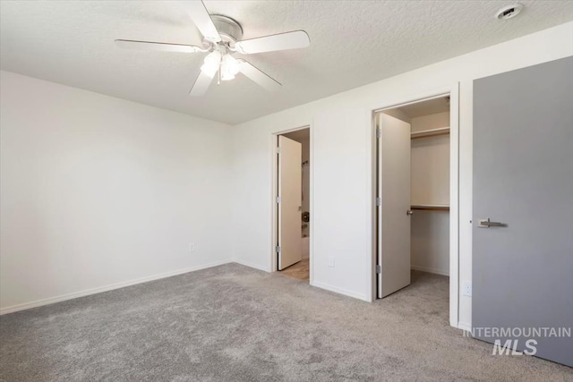 7267 Bowmont Rd, Nampa, ID 83686 - unfurnished bedroom with a walk in closet, carpet floors, a closet, baseboards, and ceiling fan