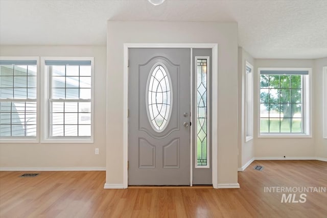 7267 Bowmont Rd, Nampa, ID 83686 - entryway featuring light wood-type flooring, baseboards, and a textured ceiling
