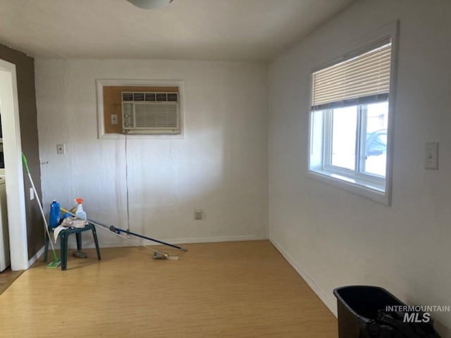 unfurnished room with a wall mounted AC and light hardwood / wood-style flooring