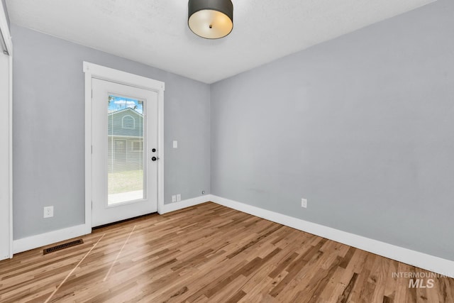 doorway with light wood-style floors and baseboards