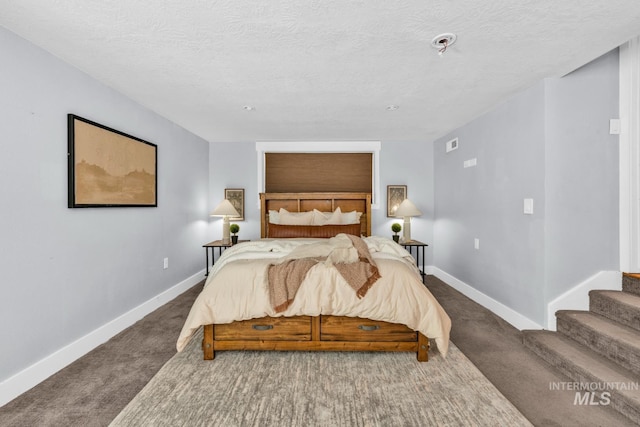 bedroom with carpet flooring, baseboards, and a textured ceiling