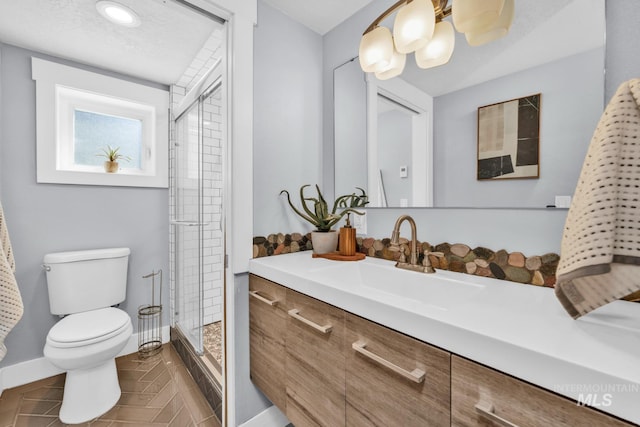 bathroom featuring toilet, a shower stall, vanity, baseboards, and tile patterned floors