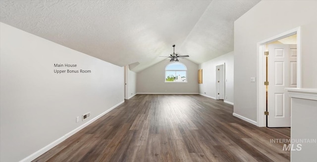 bonus room with ceiling fan, dark wood-style flooring, baseboards, lofted ceiling, and a textured ceiling
