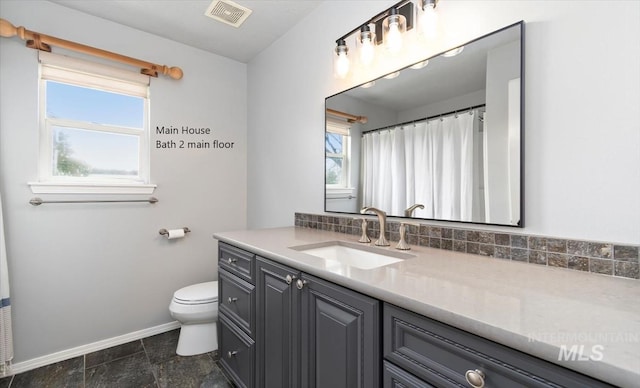 full bath with baseboards, toilet, and vanity