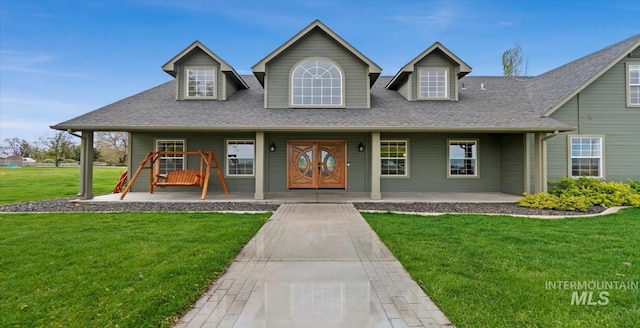 view of front of house with covered porch, a front yard, and roof with shingles