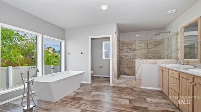 full bathroom with walk in shower, vanity, wood finished floors, toilet, and a freestanding bath