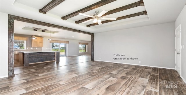 unfurnished living room with dark wood-style flooring, beam ceiling, baseboards, and ceiling fan