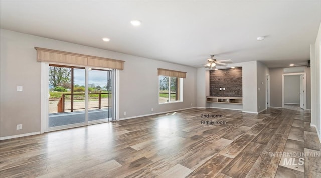 unfurnished living room with wood finished floors, ceiling fan, baseboards, and recessed lighting