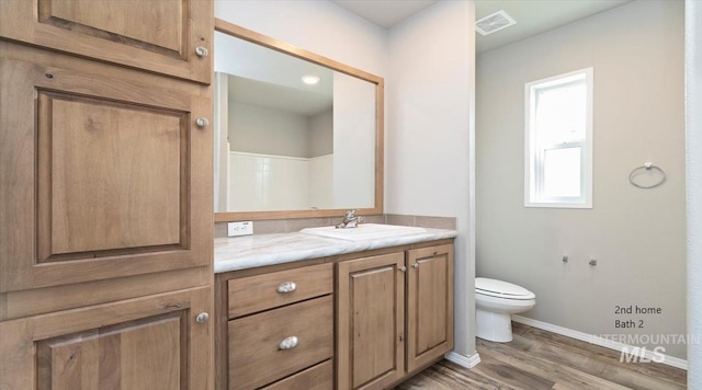 full bath with wood finished floors, toilet, baseboards, and vanity
