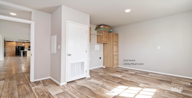 unfurnished room with light wood finished floors, baseboards, and recessed lighting