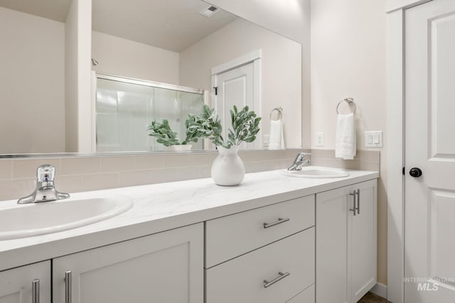 bathroom with vanity, tasteful backsplash, and an enclosed shower