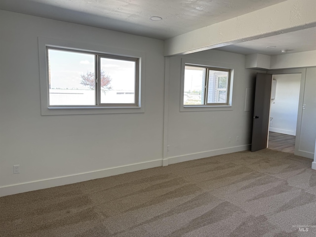 carpeted spare room with baseboards