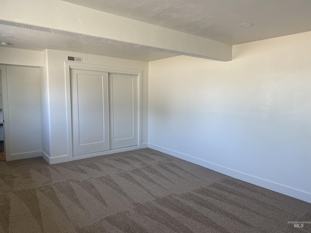 unfurnished bedroom with visible vents, carpet, baseboards, and a closet
