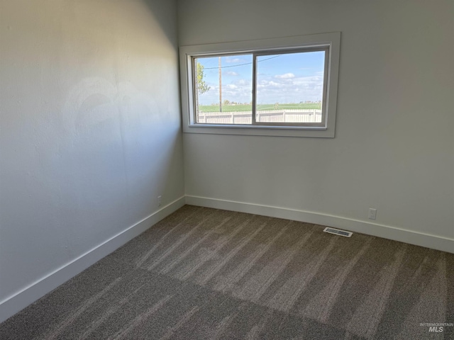 carpeted spare room with baseboards and visible vents