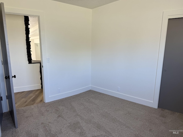 empty room with carpet floors and baseboards